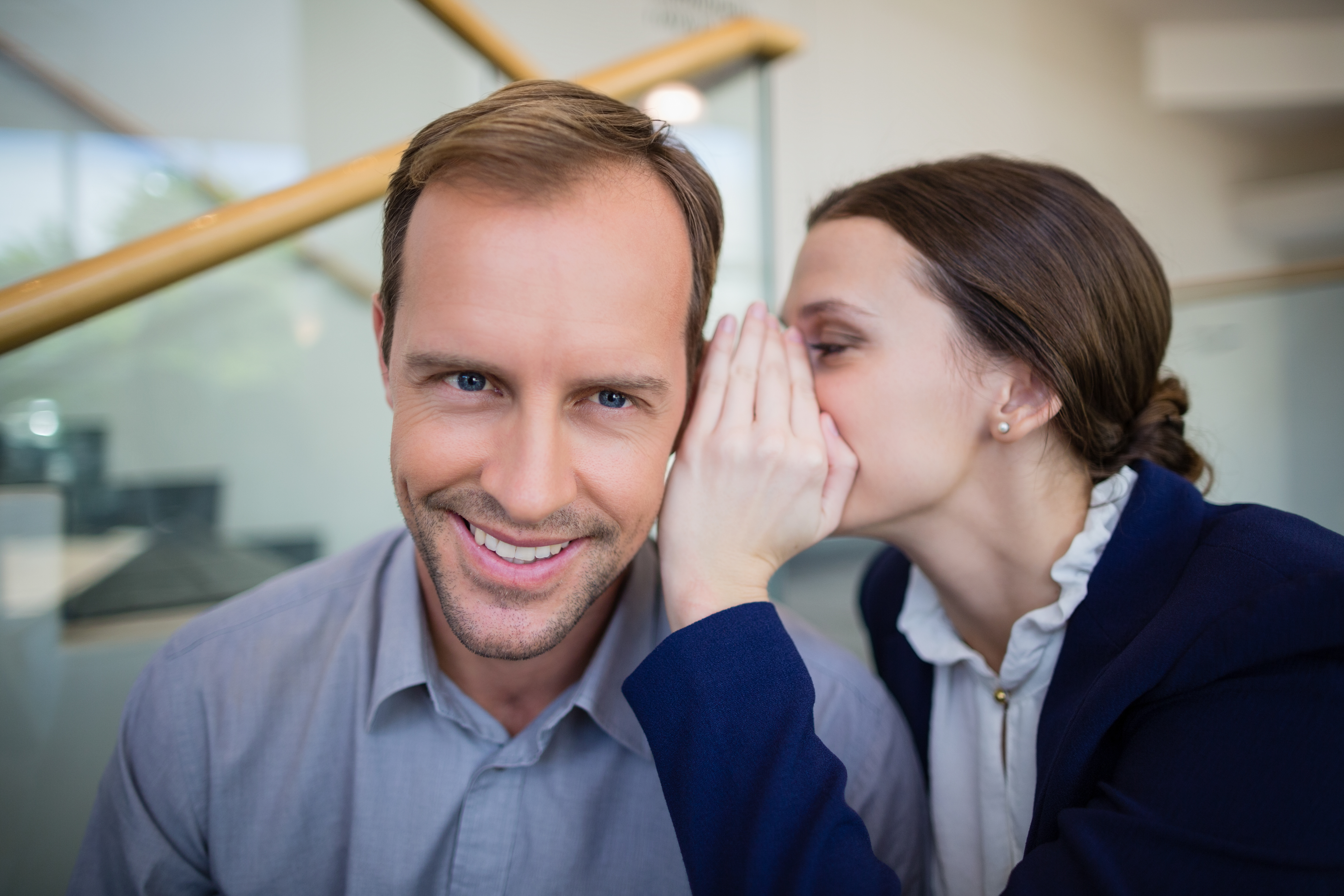 business woman whispering to colleague